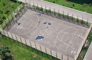 Picture of a basketball, volleyball combination asphalt sports court.