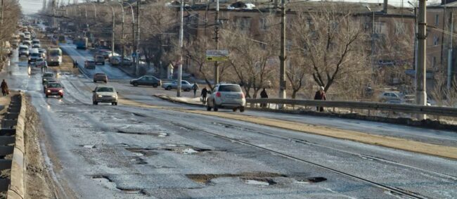 Potholes - A picture of a city street with terrible pothole damage.