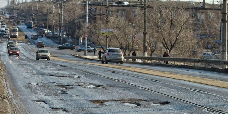 Potholes - A picture of a city street with terrible pothole damage.